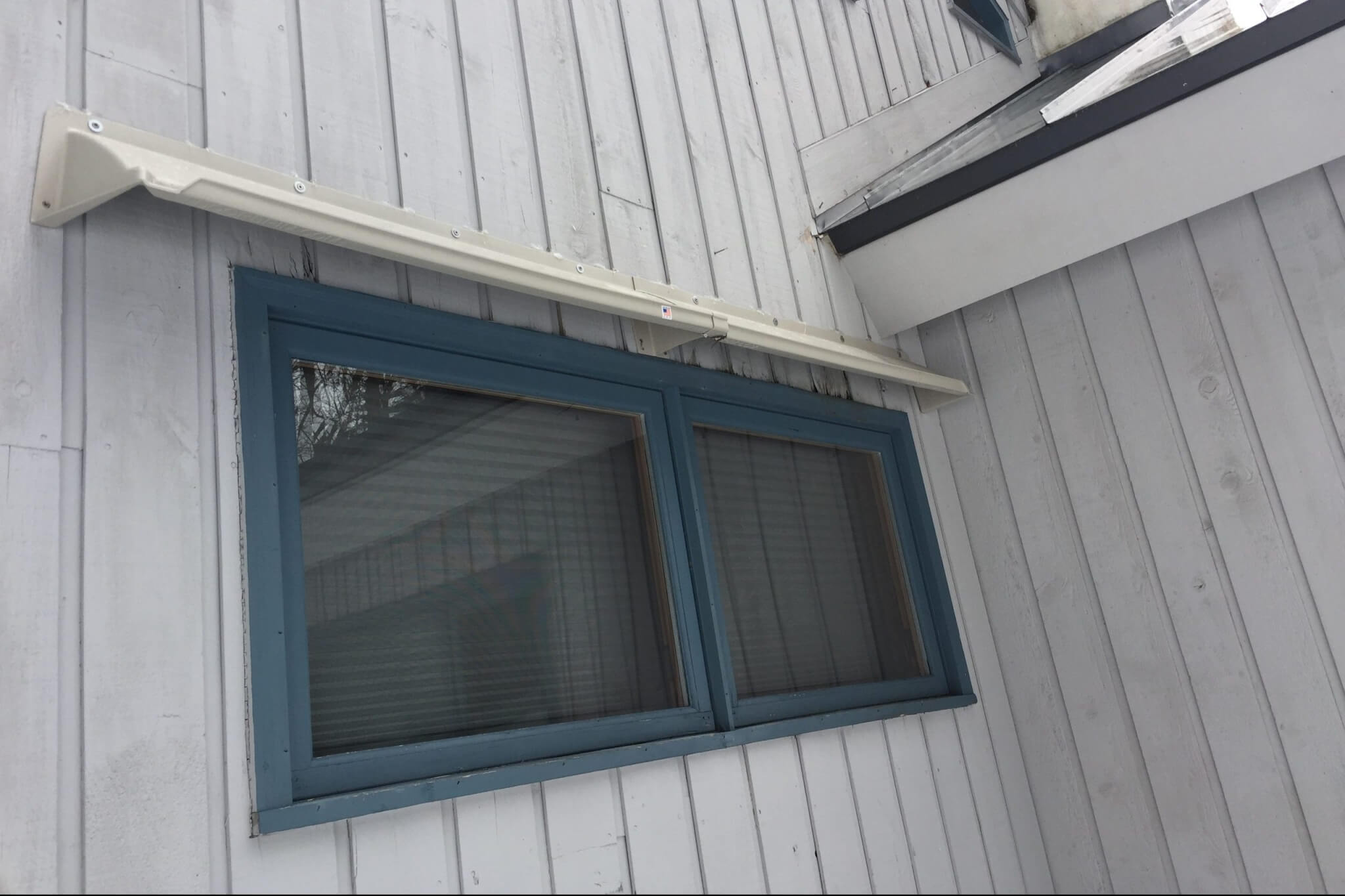 DOORBRIM rain guard mounted above an exterior window to stop leaking.