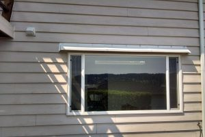 DOORBRIM rain guard mounted above an exterior window.