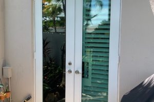 Image of a DOORBRIM rain diverter mounted above 2 full glass panel French doors.