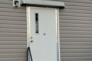 image of gray rain diverter mounted above a mobile home entrance door.