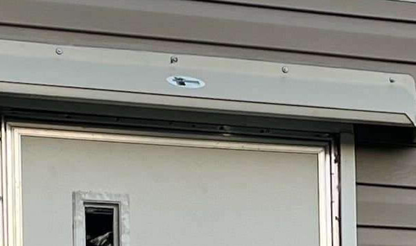 image of gray rain diverter mounted above a mobile home entrance door.
