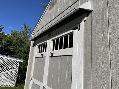 DOORBRIM rain drip guard mounted above double shed doors.
