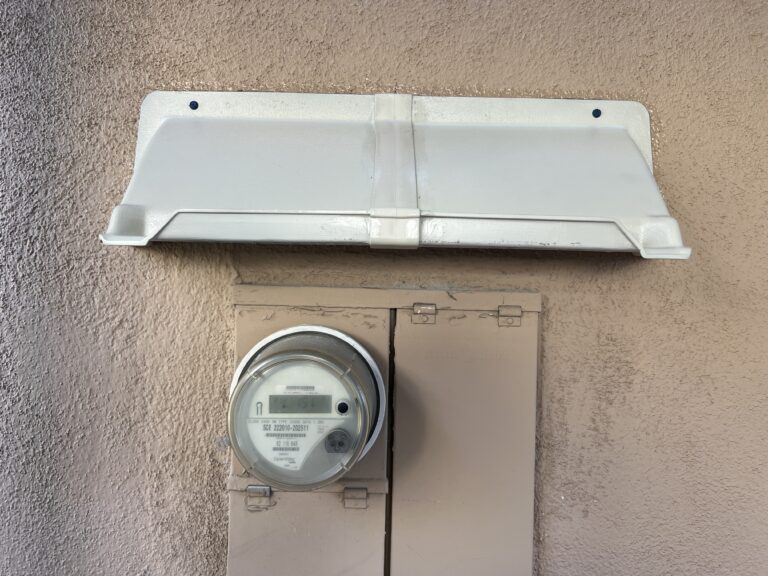 Rain hood above electric service box.