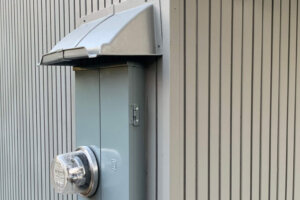 Gray rain hood over electric service panel.