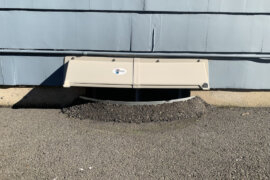 DOORBRIM rain hood mounted above basement window well.