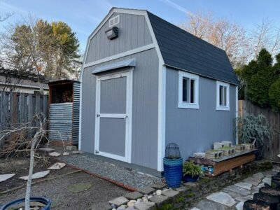 Gray DOORBRIM rain diverter mounted above a shed door.