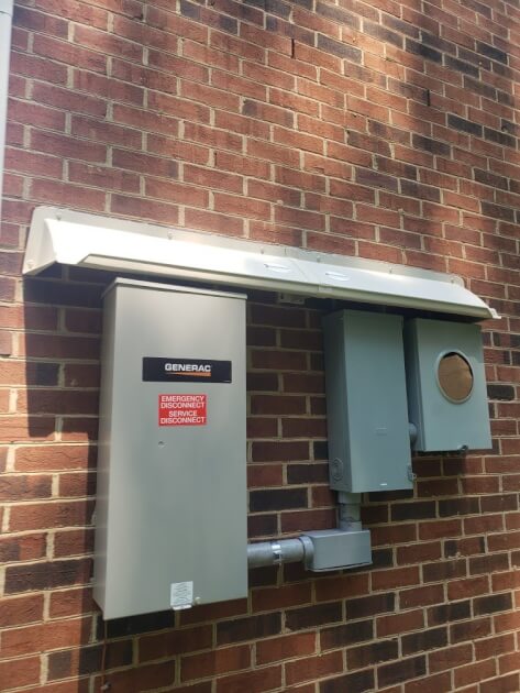 DOORBRIM rain diverter installed above Generac GENERATOR electrical equipment..