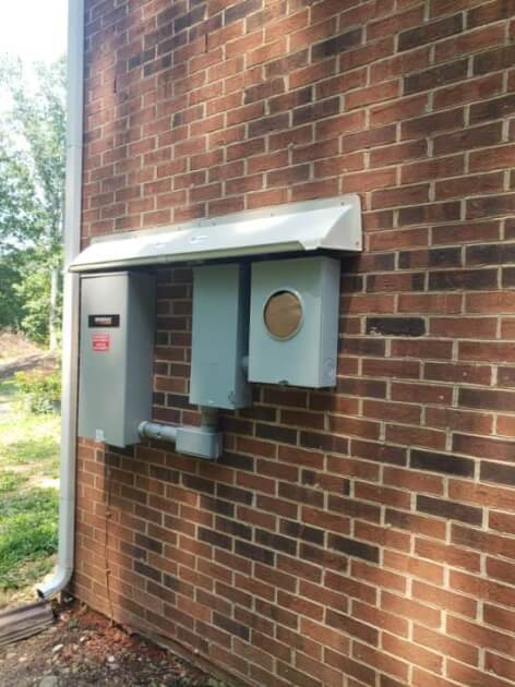 DOORBRIM rain diverter mounted above Generac switchgear